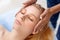 Cosmetology Service. Young woman at beauty clinic lying closed eyes while doctor touching head preparation for procedure