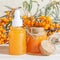 Cosmetology, traditional alternative medicine, herbal medicine, natural sea buckthorn vegetable oil in a glass jar on a table