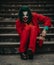 Cosplayer in the image of a crazy clown sits handcuffed and laughs