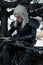 Cosplayer portrays a character Geralt of Rivia from the game or film The Witcher and cleans his sword at winter forest