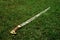 A Cossack saber with a wooden handle lies on the ground, green grass. Cold steel