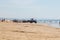 Costa da Caparica, Portugal - September 10, 2020: An artel of fishermen trawls fish from the tourist beach using a tractors.