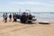 Costa da Caparica, Portugal - September 10, 2020: An artel of fishermen trawls fish from the tourist beach using a tractors.