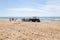 Costa da Caparica, Portugal - September 10, 2020: An artel of fishermen trawls fish from the tourist beach using a tractors.