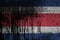 Costa Rica flag depicted in paint colors on old and dirty oil barrel wall closeup. Textured banner on rough background