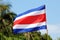 Costa Rica flag waving at Manuel Antonio national park beach in most beautiful beaches in the world, surfer beaches in America