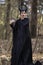 Costume Drama. Marvellous and Magical Maleficent Woman with Horns Posing in Spring Empty Forest with Crook