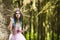 Costume Play.  Sensual Magnificent Crowned Forest Nymph with Flowery Golden Crown Posing in Summer Forest Against High Tree Stem