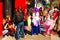 Costumed children and their parents trick or treat through a downtown district on a sunny Halloween day