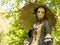 Costumed and masked woman at venetian carnival with golden umbrella. Blu sky and trees in the background.