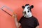 Costumed person with a cow`s head mask holding a saw