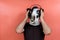 Costumed person wearing a cow mask listening music with headphones