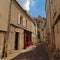Cosy cobblestone street with restaurant and old houses and medieval gate in Senlis, France