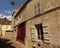 Cosy cobblestone street with traditional restaurant and old houses and medieval gate in Senlis, France