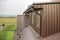 Cottage attic room, roof and walls covered with brown metal siding planks, new gutter system.