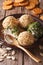 Cottage cheese balls with crackers, herbs and pumpkin seeds close-up. vertical