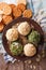 Cottage cheese balls with crackers, herbs and pumpkin seeds close-up. vertical top view