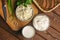 Cottage cheese in bowl, cream and milk and fresh herb on wooden cutting board on table. Healthy food