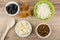 Cottage cheese in bowl, raisins, pieces of banana, prunes