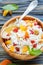 Cottage cheese with dried fruit and honey in a wooden bowl.