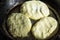 Cottage cheese fritters frying in iron cast pan in oil, rural style