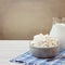 Cottage cheese and jug with milk on white wooden table. Jewish holiday Shavuot concept