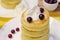 Cottage cheese pancakes with sour cream and berries on yellow ba