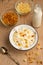 Cottage cheese with raisins and pineapple zucchini, with milk in a bowl on a wooden table. Diet, tasty and healthy food