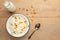 Cottage cheese with raisins and zucchini, with milk in a bowl on a wooden table. Diet, tasty and healthy food