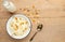 Cottage cheese with raisins and zucchini, with milk in a bowl on a wooden table. Diet, tasty and healthy food