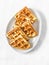 Cottage cheese waffles - delicious sweet dessert on a light background, top view