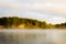 A cottage in the distance on the lake in the light of the sunrise.