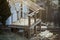 Cottage house building under construction with walls made of hollow foam insulation blocks, wooden roof frame and attached porch