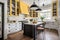 a cottage kitchen featuring white cabinetry, yellow accents, and black details