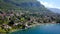 Cottage town on background of mountain and blue lake. Action. Top view of paradise vacation spot in country town in