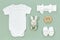 Cotton baby bodysuit for mockup on a mint green background. Infant accessories and wooden toys next to white romper for kids