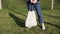 Cotton bag in women`s hands, against the background of green grass in the park. The concept of recycling and