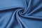 Cotton brushing fabric satin  of saturated blue color beautifully folded in a view spiral