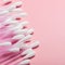 Cotton buds on a pink background. Hygienic supplies, a tool for beauty. Top view, copy space