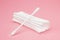 Cotton cosmetic swabs for ear cleaning. Personal care, personal hygiene. Hygienic sanitary swabs on the pink background. Selective