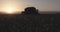 Cotton harvester harvesting in a cotton field during sunset