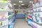 Cotton pads, wet wipes, diapers for adults, absorbent diapers and water bottles on the shelves and counter with medicines and othe