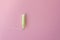 Cotton tampon with light green applicartor on a pink background. Woman days hygiene protection. Menstrual cycle period concept.