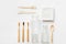 Cotton washcloth bamboo toothbrushes wooden cutlery glass bottle jar on white background. Zero waste plastic free eco friendly