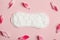 cotton white sanitary pad with fresh pink flower petals on pastel rose background, menstruation cycle, intimate hygiene, top view