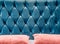 Couch-type velours screed on headboard tightened with buttons. Blue chesterfield style quilted upholstery backdrop close