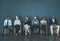 It could be anyone of us. Shot of a group of well-dressed business people seated in line while waiting to be interview.