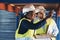 We could use this. two young contractors standing together and examining the scaffolding in the warehouse.