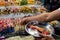 Counter with Chinese street food, the buyer fills a plate with bacon. food on sticks.