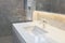 Counter top white marble with washbasin.Wall and floor beige,grey marble stone interior design of restroom or toilet background.Re